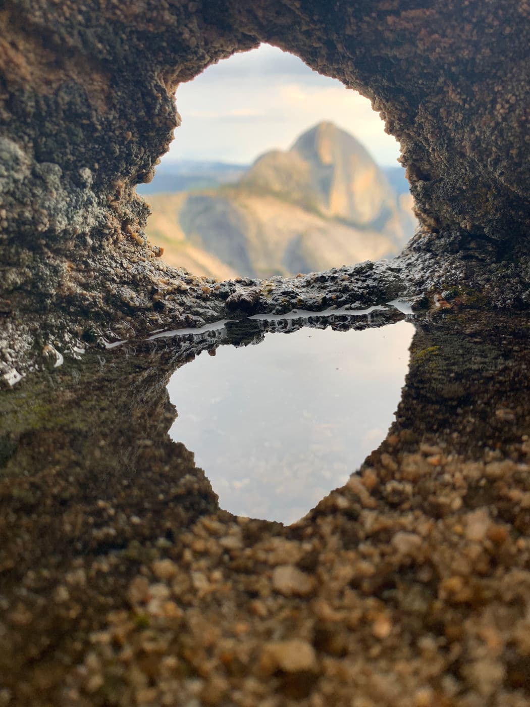 I took this photo from Mt. Watkins in Yosemite through a little hole in a rock that had a pool of water from a recent rain.