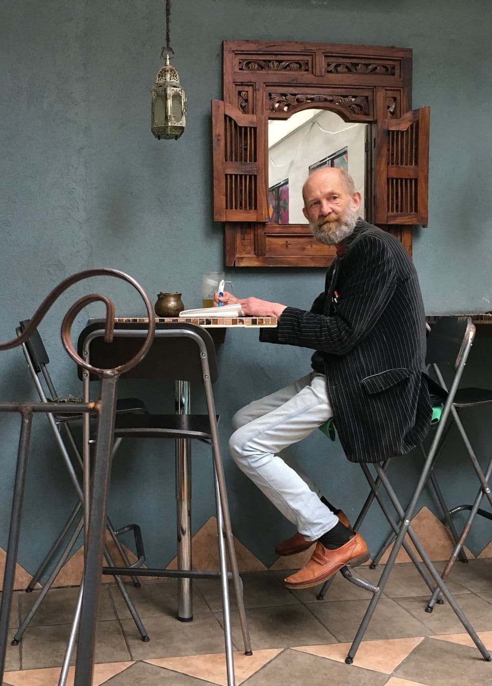 We were sitting in a little restarant in the back of a cool shop in Norway and I looked over and just loved the colors and metal shapes around this guy. I had to get the shot even though I was disturbing his privacy a bit. :)